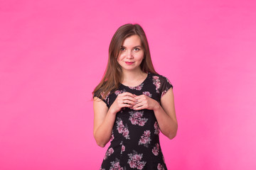 Young woman in elegant summer dress. Girl posing on a pink background.