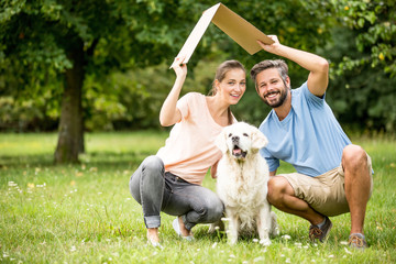 Familie mit Hund hält ein Dach