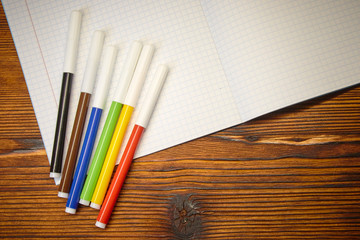 Obraz premium Study. colored markers and notebook on wooden background