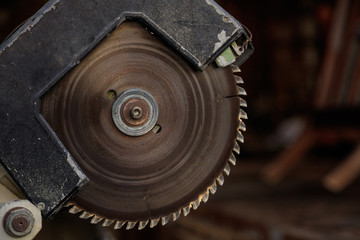 Electric saw old and peeled with circular jagged disc for woodwork. Blur background, closeup, detail