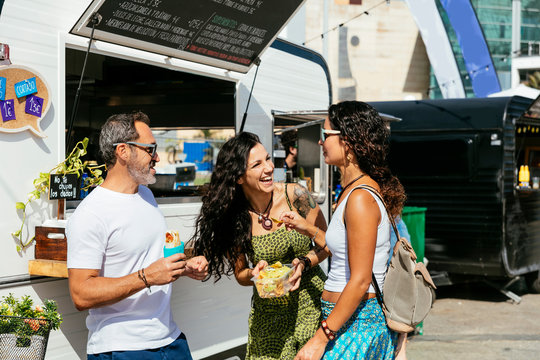 Women and man at food truck - Powered by Adobe
