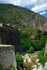 Fototapeta na wymiar The River Tet runs by the pretty walled town of Villfranche de Conflent in the south of France. This medieval city dates back to the 11th century