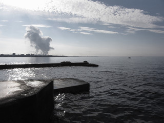Industrial landscape along the coast. Air polluting factory chimneys