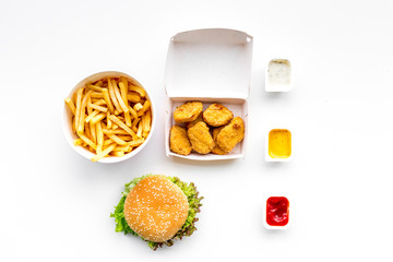 Fast food. Chiken nuggets, burgers and french fries on white background top view