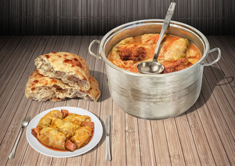 Plateful Of Gourmet Pickled Cabbage Rolls Cooked With Smoked Pork Ham Chunks Served With Fresh Domestic Fireplace Baked Leavened Pitta Flatbread Torn Loaf On Rustic Wooden Slatted Place Mat