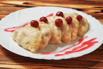 White plate with sweet boiled dough vareniki with cherry. Ukrainian national dish.