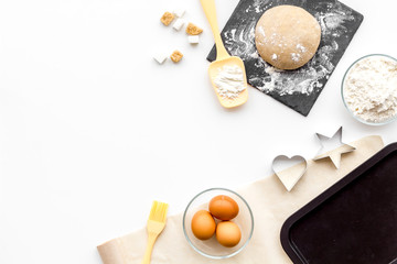Ball of fresh raw dough near ingedients and cookware on white background top view copy space