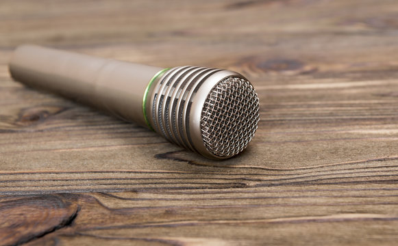 the microphone rests on a wooden table. concept music, performer. karaoke