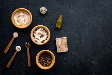 Aromatic spa cosmetics. Chocolate brown spa salt on black background top view copy space