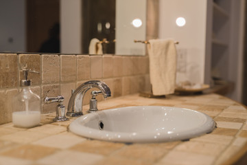 Bathroom sink with large mirror and natural tiles