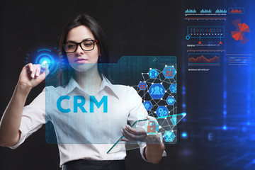 The concept of business, technology, the Internet and the network. A young entrepreneur working on a virtual screen of the future and sees the inscription: CRM