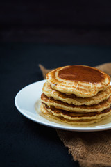 appetizing pancakes with honey on a dark table. Menu , restaurant recipe concept. Served in.