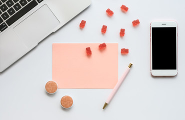 Feminine Tech Workspace with Laptop, Mobile Phone, Blank Note, Office Accessories, Pink Gummy Bears