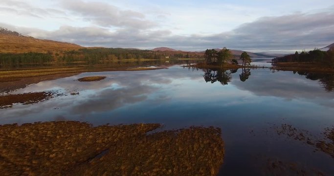 aerial footage of flying over a calm mirrorlike scottish loch in the remote highlands of scotland at loch tulla