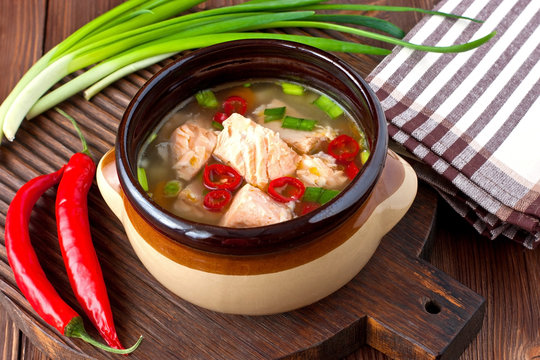 Fresh fish soup with ingredients and spices for cooking. Wooden background. 