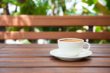 Cup of hot latte art coffee on wooden table.