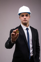 Handsome business man crypto miner in protective hemlet with bitcoin i isolated on white background