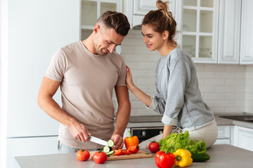 Portrait of an attractive loving couple cooking salad