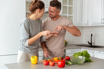 Portrait of a young loving couple cooking salad together