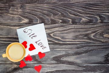 On a wooden background are the hearts with a cup of coffee. Valentine's day concept.