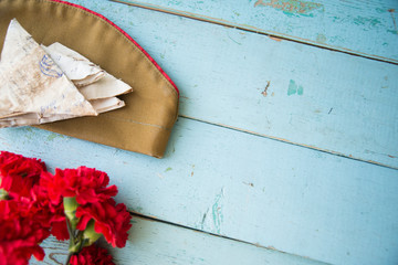 background for postcards by may 9, victory day: cap, letters, carnations and St. George ribbon