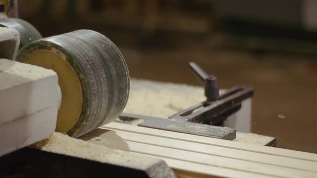Wood board running out carpenter refiner machine at sawmill factory, lots of sawdust