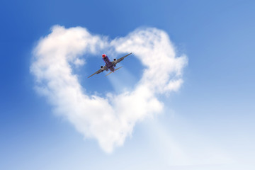 Fototapeta na wymiar The plane flew through a white heart-shaped cloud. On a bright day, glow bright with hope.