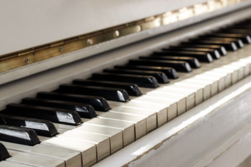 White piano, side view of instrument, musical instrument. learn to play the instrument at home. white large piano. piano keyboard. concert concept.