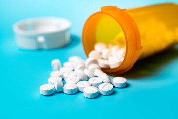 white pills in a yellow plastic bottle
