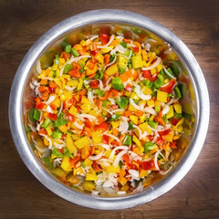 Colored pepper and onion are sliced in a bowl. top view close up