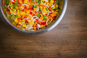 Colored pepper and onion are sliced in a bowl. top view close up