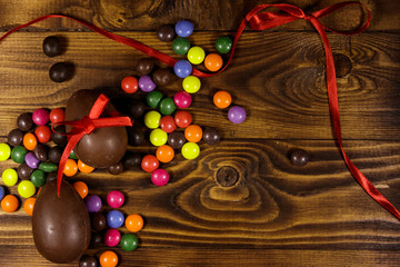 Easter composition with chocolate eggs on wooden background
