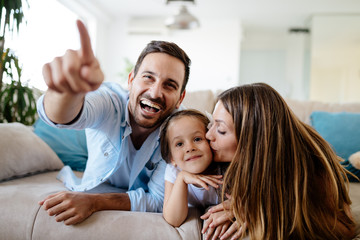 Obraz premium Happy family watching television at their home