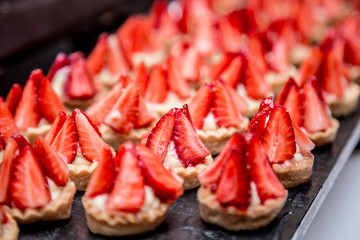Canapes with strawberry dessert on the banquet table.