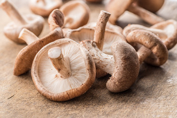 Shiitake mushrooms on the wooden background.