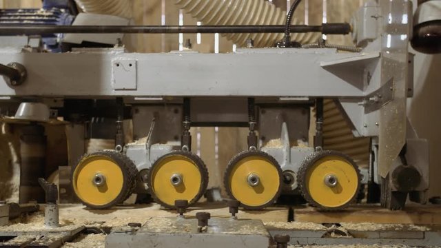 Running spiked wheels of board refiner machine working on wood at sawmill production, close up
