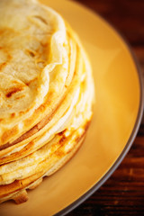 Russian Maslenitsa, Shrovetide, pancake week, carnival, shrove, pancake day. a stack of pancakes with butter upstairs on plate, on wooden background, close-up