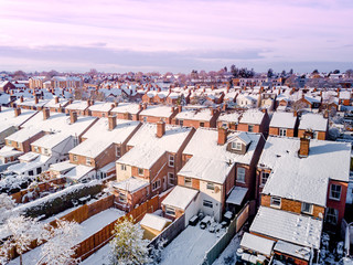 Aerial view of snow covered traditional housing suburbs in England. Snow, ice and adverse weather conditions bring things to a stand still in the housing estates of a British suburb