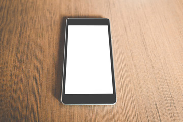 Black smart phone with blank screen in wood table. technology concept.