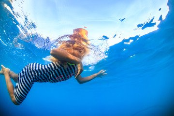 Fototapeta na wymiar little blonde girl in sea water underwater