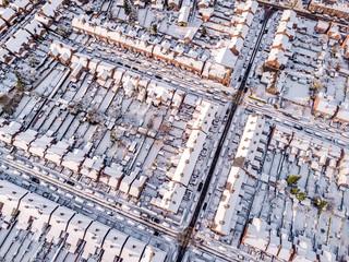 Aerial view of snow covered traditional housing suburbs in England. Snow, ice and adverse weather...