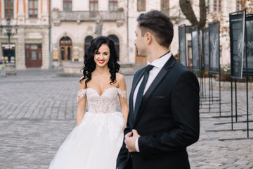 Naklejka premium Bride and groom walking through the old town