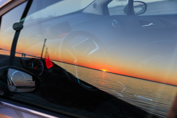 The sunset is reflected in car glass