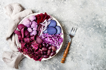 Obraz na płótnie Canvas Purple Buddha bowl with spiral carrots, cauliflower, beet, onion, potato, shredded red cabbage, radicchio salad, kalamata olives. Vegan detox veggie bowl