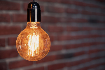Decorative antique edison style light tungsten bulbs against brick wall background