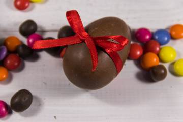 Easter composition with chocolate eggs on white wooden background