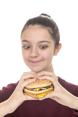 Adolescent girl enjoying a hamburger on a white background