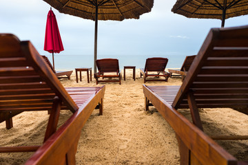 Bad cloudy weather in wet low season.  Nobody on the beach. Empty sun beds