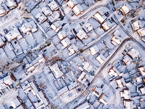 Aerial view of snow covered traditional housing suburbs in England. Snow, ice and adverse weather conditions bring things to a stand still in the housing estates of a British suburb