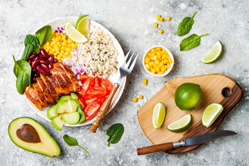 Homemade Mexican chicken burrito bowl with rice, beans, corn, tomato, avocado, spinach. Taco salad lunch bowl © sveta_zarzamora